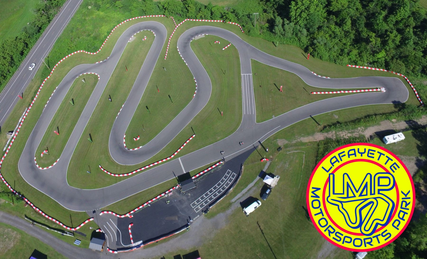 Aerial view of the LaFayette Motorsports Park asphalt road course with red-and-white curbing